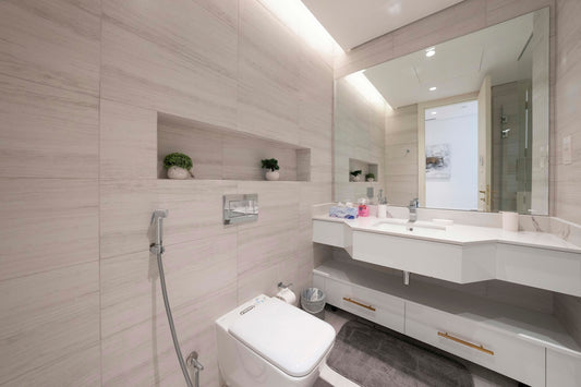 A bathroom with a toilet, sink, and mirror