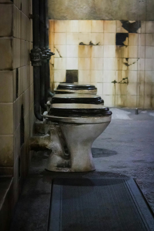 A row of toilets sitting next to each other in a bathroom