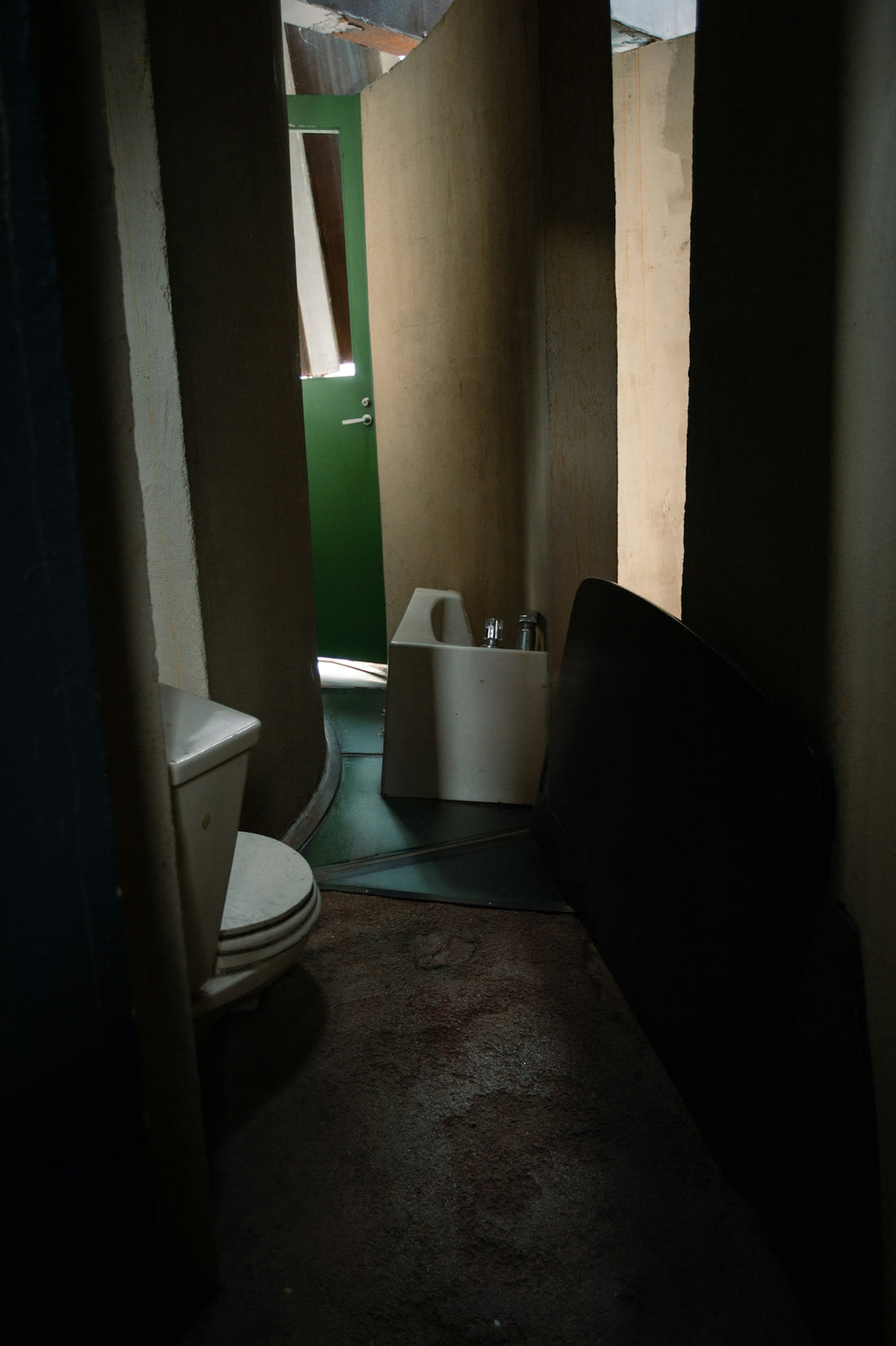 A dimly lit bathroom with a toilet and sink.