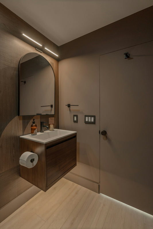 Modern bathroom vanity with arched mirror and wood accents