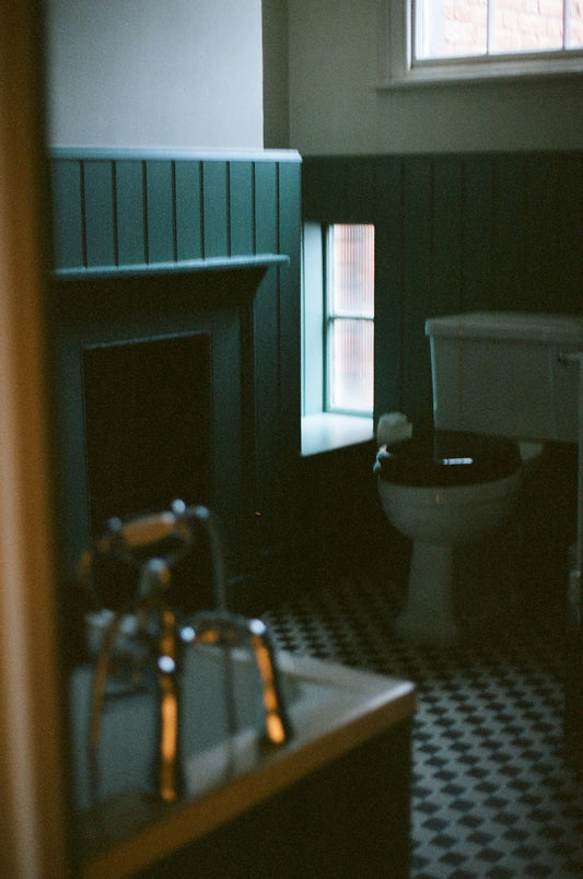 Dark bathroom with vintage fireplace and checkered floor